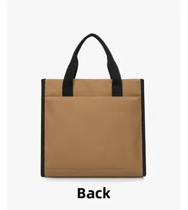 Back view of khaki canvas tote bag with black handles and large exterior pocket