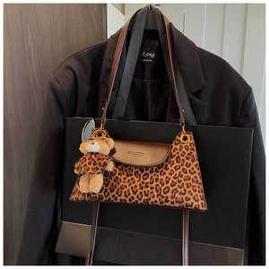 Détail du sac à main léopard avec rabat en cuir marron et charmant ours en peluche
