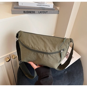 Close-up of an olive green nylon crescent crossbody bag with detailed fabric texture