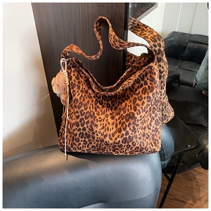 Close-up of leopard print tote bag with soft suede texture and cute plush bear charm