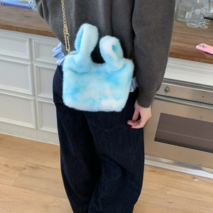 Detailed close-up of blue and white cloud plush bucket bag with golden chain strap