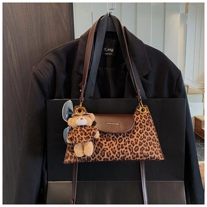 Détail du sac léopard avec pendentif ours portant des lunettes de soleil et un sweat à capuche