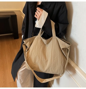 Gros plan d'un sac cabas kaki texturé plissé avec large bandoulière sur mannequin