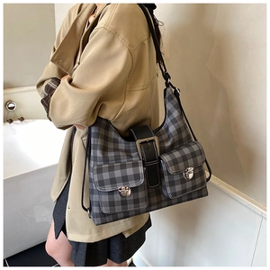 Detail of checkered tote bag featuring dual front pockets and metallic twist locks
