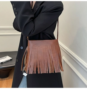 Detail der braunen Vintage-Leder-Beuteltasche mit dichten Fransen und Hochglanz-Finish