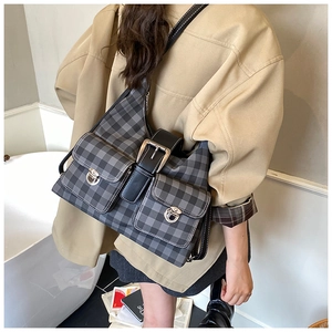 Detail view of retro grey plaid hobo bag with large metal buckles on model