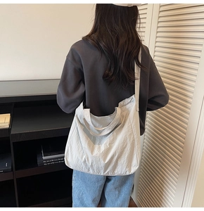 Vue détaillée d'un sac cabas blanc avec texture plissée et large bandoulière