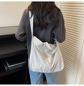 Détail d'un grand cabas blanc plissé montrant sa texture et sa capacité sur un mannequin