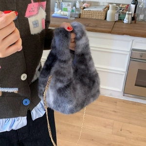 Detail of grey tiger-striped faux fur handbag with a sleek golden chain strap