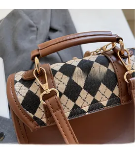 Detail of vintage checkered handbag featuring premium gold metal lock and leather texture