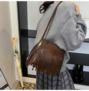 Detail einer braunen Kunstleder-Beuteltasche mit langen Fransen im Bohème-Retro-Stil