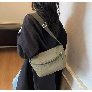 Detail of army green nylon crossbody bag with adjustable wide strap and zip pocket