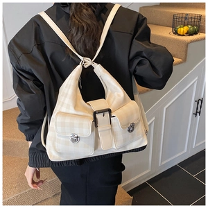Detailed back view of a beige checkered tote backpack with multi-pocket design on a model