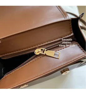Macro view showing the smooth gold metal zipper on brown pebble leather backpack