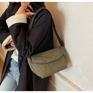 Detail of army green nylon crossbody bag showing the adjustable strap and zipper