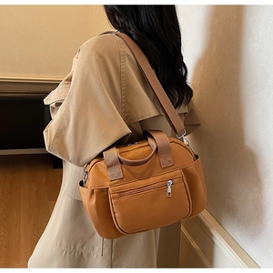 Brown nylon crossbody bag shown worn by a model in a warm indoor setting for style