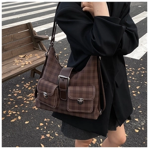 Close-up of a vintage brown checkered hobo bag with multiple front buckle pockets for women