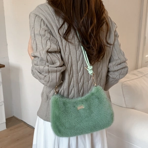 Détail du sac à bandoulière en peluche vert clair avec finitions dorées et texture