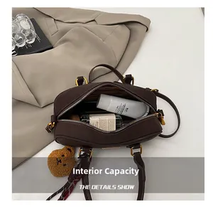 Top view of vintage brown leather bowling bag showing spacious interior and plush bear charm