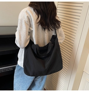 Détail du grand sac cabas noir en nylon porté à l'épaule au style décontracté et élégant