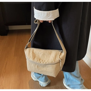 Detail of khaki nylon dumpling bag showing lightweight fabric and adjustable wide strap