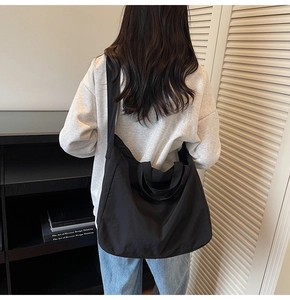 Vue détaillée d'un grand sac cabas en nylon noir sur un mannequin montrant sa grande capacité