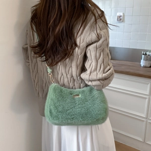 Détail d'un sac à bandoulière en peluche vert clair avec des finitions dorées chic