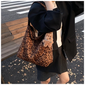 Outdoor shot of large leopard print hobo tote bag with a cute brown plush bear charm