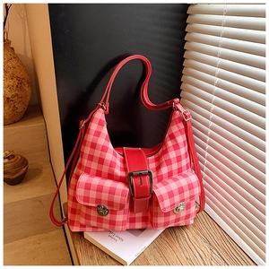 Close-up of red and pink checkered hobo bag with front flap pockets and silver twist locks