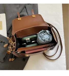 Brown leather crossbody bag interior showing storage space for phone, umbrella and wallet