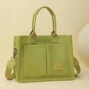 Détails du sac cabas en toile vert herbe avec doubles poches avant et bandoulière large
