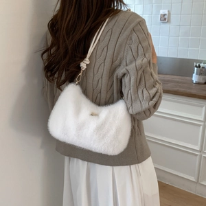 Détail d'un sac à main blanc en peluche avec bandoulière en corde et fermeture éclair métal