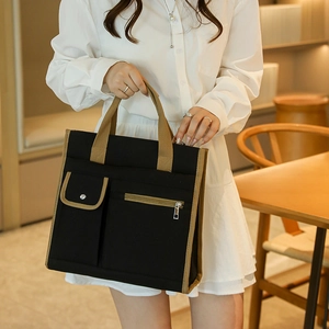 Detail view of canvas tote bag with contrast stitching and multi-pocket functional design