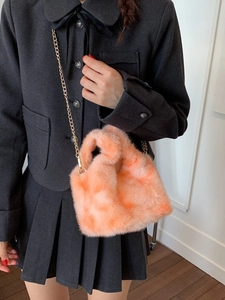 Chic orange-pink plush bucket bag with golden chain strap for stylish winter outfits