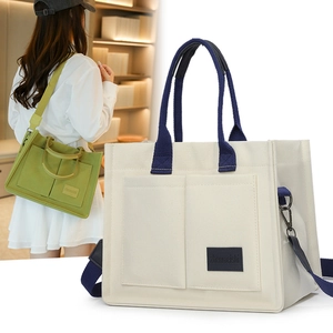 Détail du sac fourre-tout en toile avec deux poches avant et bandoulière large réglable