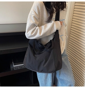 Side view of a large black commuter tote bag worn over the shoulder for a casual urban style