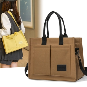 Vue détaillée du grand sac en toile avec poches carrées avant et large bandoulière