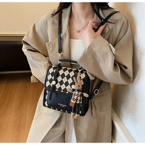 Detail of quilted leather crossbody backpack with metallic buckle and cute plush charm