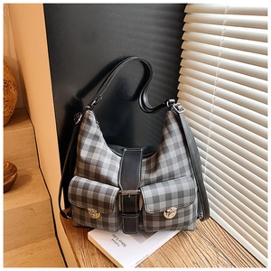 Close-up of retro plaid tote bag showing front pockets and metal buckle details