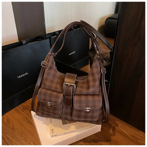 Detail of vintage brown plaid hobo bag featuring multiple pockets and metal buckles