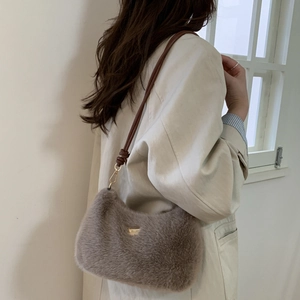 Détail du sac à bandoulière en peluche marron clair avec lanière cuir et boucles dorées