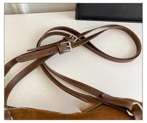 Detail of adjustable double shoulder straps with silver buckles on leopard pillow bag