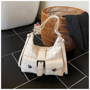 Detail of checkered tote bag with two front flap pockets and silver metal buckles