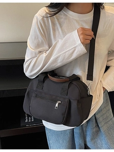 Black nylon casual crossbody bag with brown leather handles and adjustable strap