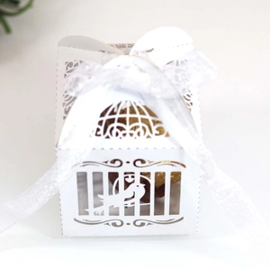 Close-up of laser-cut hollow candy box with gold lining and white organza ribbon