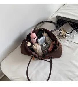 Spacious interior of dark brown suede tote bag holding umbrella, wallet and bottle