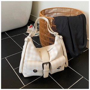 Detail of cream checkerboard canvas tote with silver twist-locks and dual front pockets