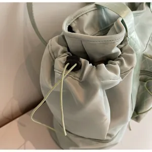 Close-up of mint green travel bag featuring a durable drawstring closure and reinforced seams