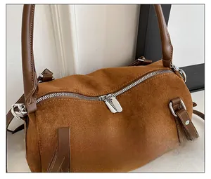 Detail showing smooth silver dual zippers and brown suede leather on the Boston bag