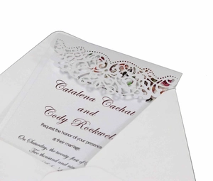 Elegant laser-cut wedding invitation set with white ornate hollow envelope and inner card